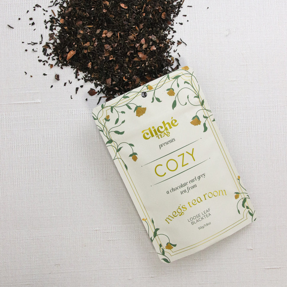 Tea packaging with loose tea spilling out on a white background