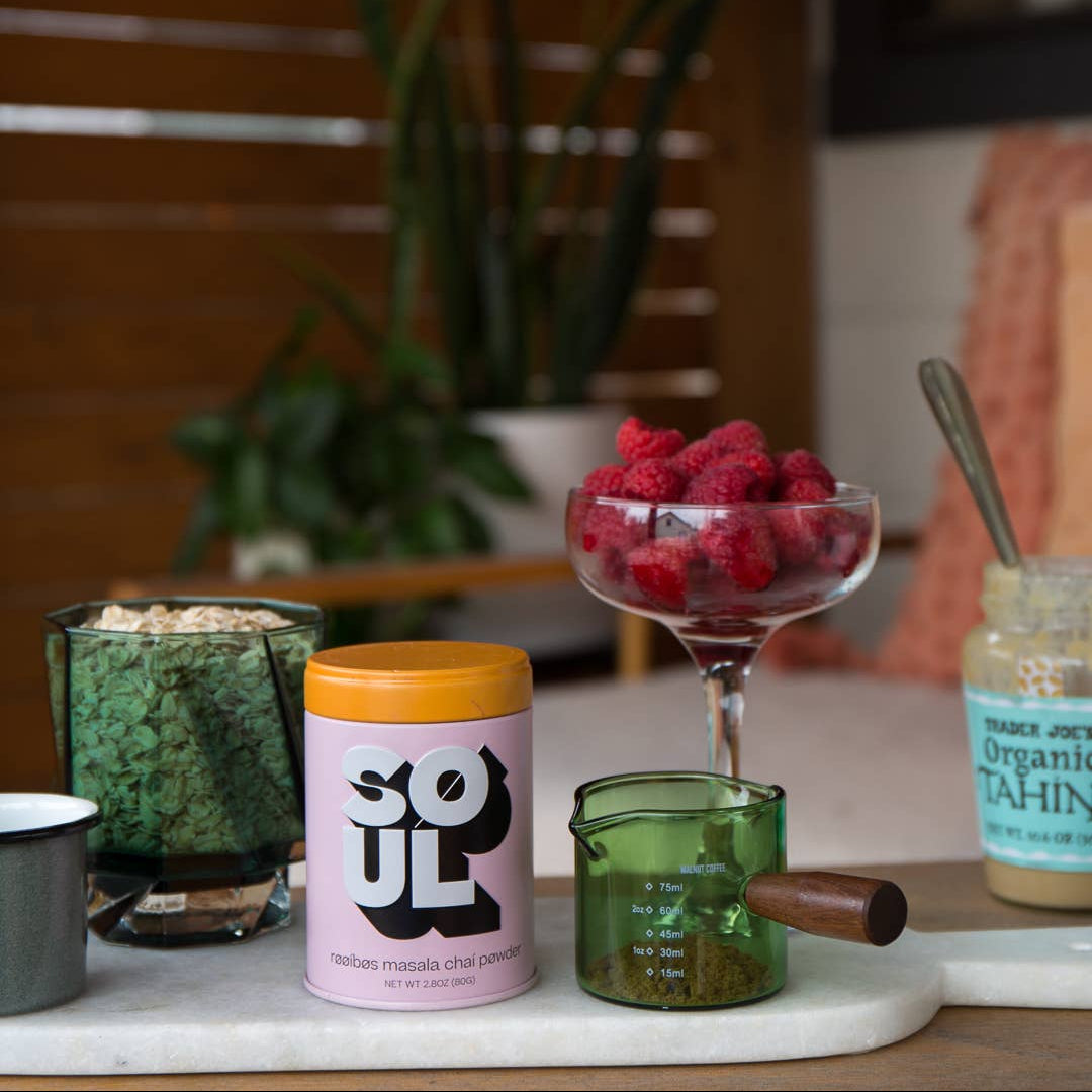 Soul jar on a table with a glass of raspberries and other items.