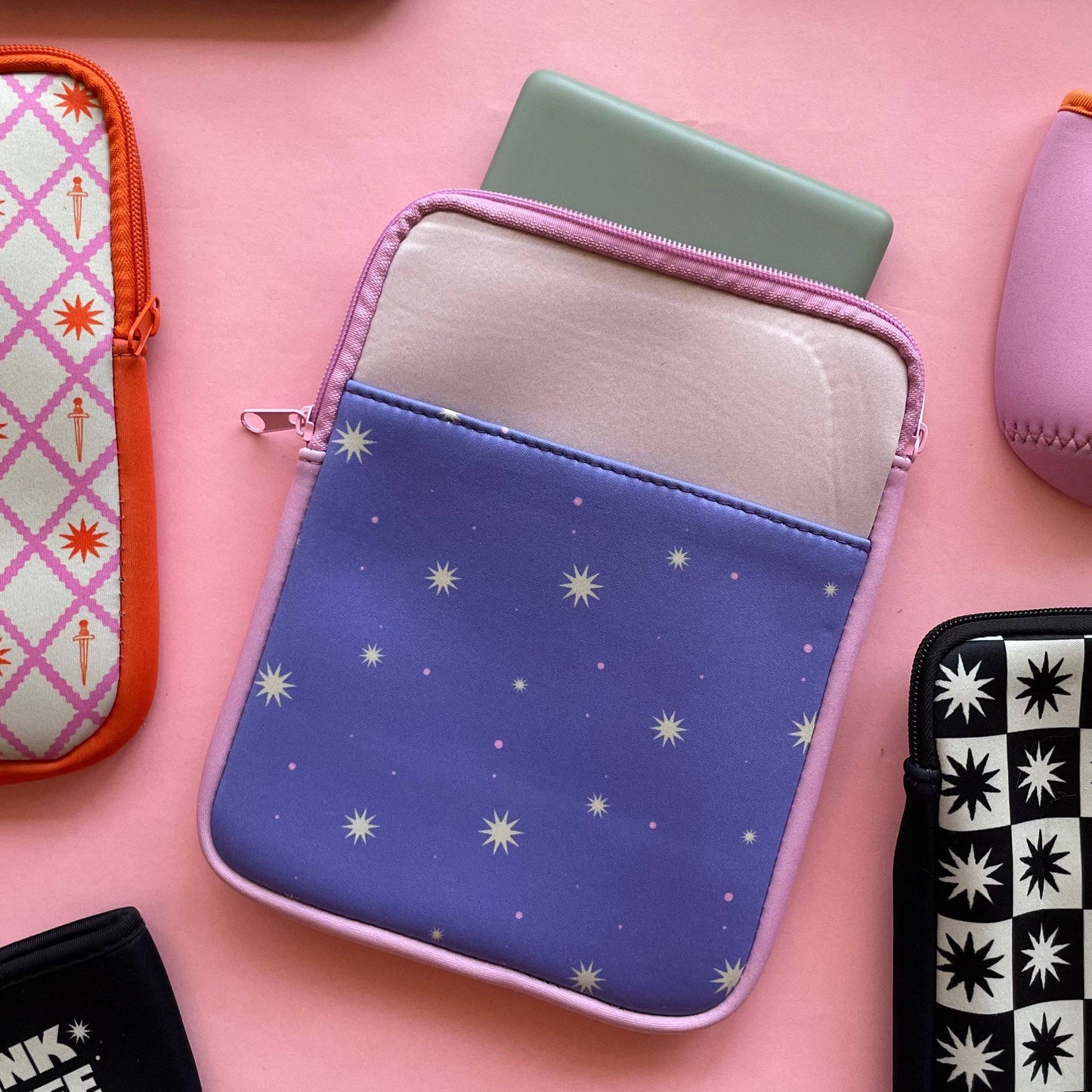 Collection of small pouches with various designs on a pink background