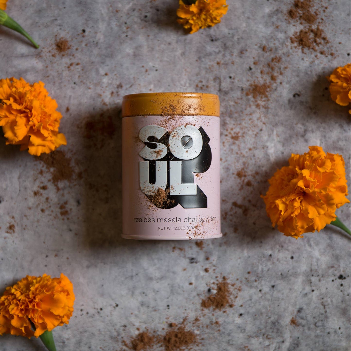 Container labeled 'Soul' surrounded by orange flowers on a textured surface