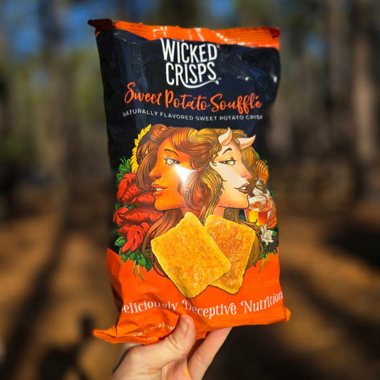 Wicked Crisps Sweet Potato Souffle packaging held in a hand with a blurred natural background